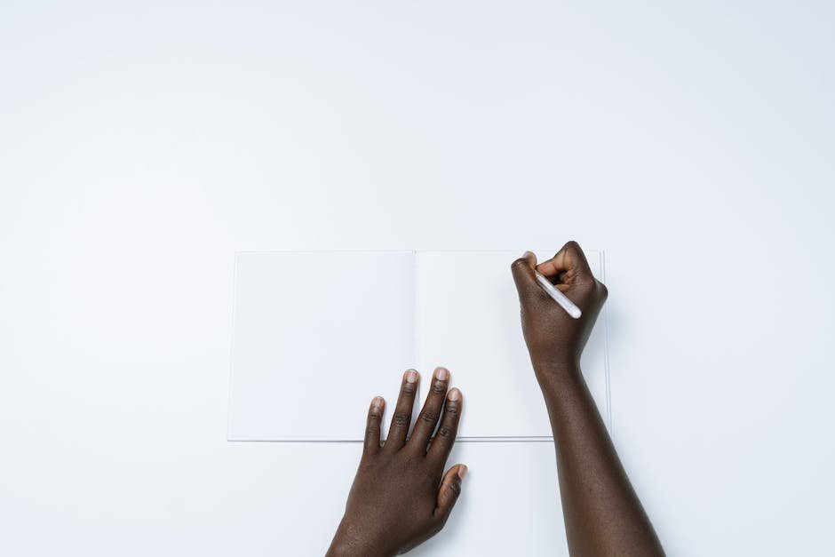 Image depicting a person signing a car title transfer document with a pen